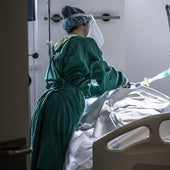 Una sanitaria, con el equipo de protección, atiende a un paciente en el San Pedro.
