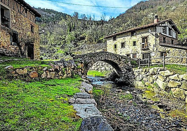 Aldeanueva de Cameros. Un riachuelo, un puente, casas de piedra y bosques alrededor.
