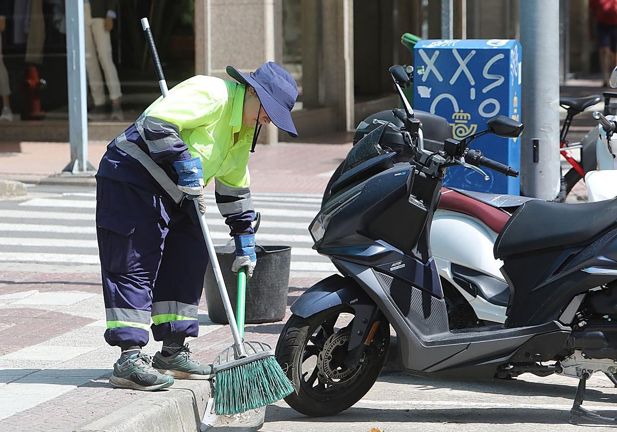 Un operario de la limpieza se cubre con un gorro para evitar una insolación.