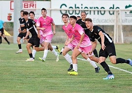 Los jugadores del Agoncillo y la UDL (de negro) buscan el balón en un centro.