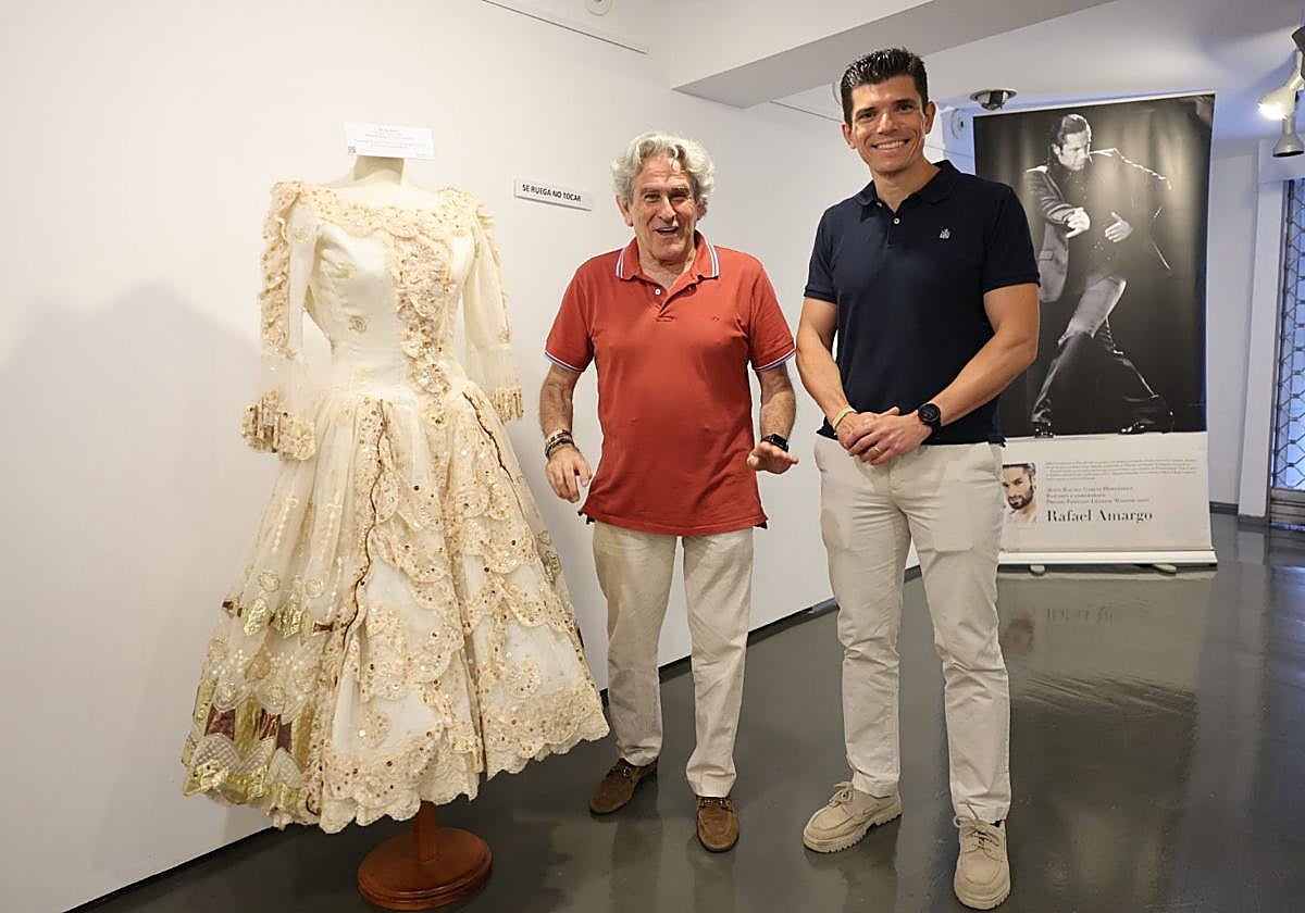 Perfecto Uriel y Juan Diego Alcaide en la inauguración de la exposición, junto al traje de Pilar Rioja.