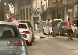 El agredido, tendido en la calle El Sol, tras la agresión junto al joven al que el entorno de la víctima atribuye la agresión.