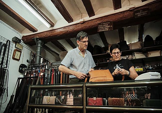 Alejandro Gainzarain, junto a su mujer Pilar Ruiz, arreglan la correa de un bolso de cuero.