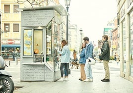 Varias personas esperan para comprar un cupón en un quiosco de la ONCE.