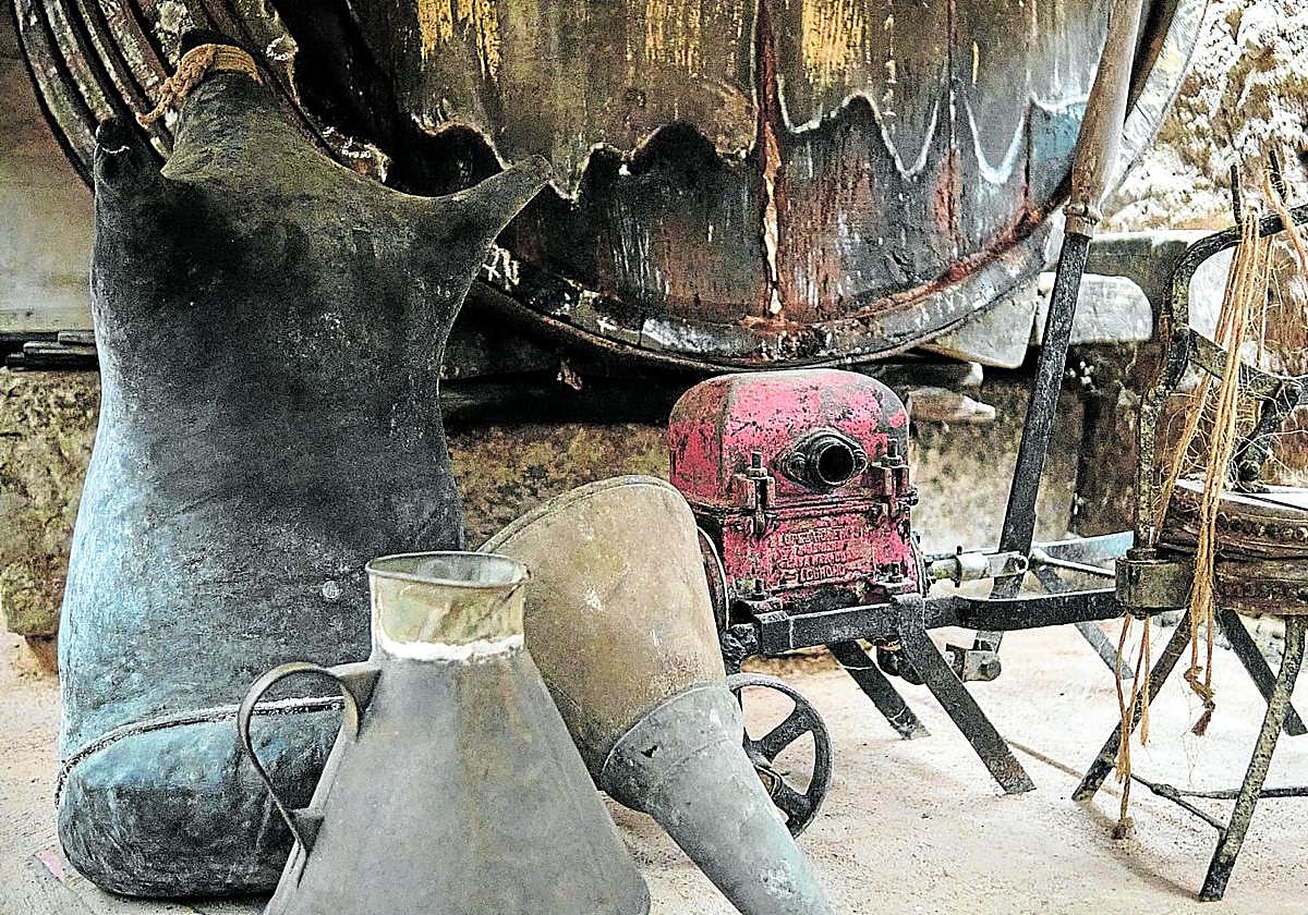 Un fudre de madera con una cántara y un pellejo para transportar el vino.