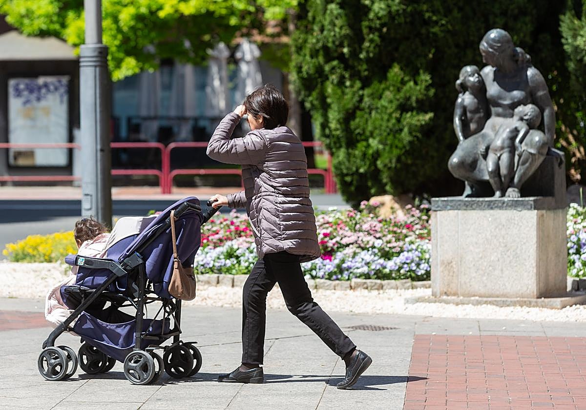 Una mujer empuja un carrito de bebé por Logroño.