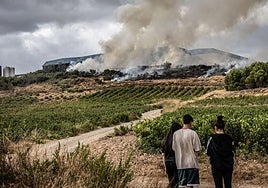 Unos jóvenes contemplan el incendio en la tarde del miércoles.