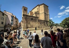 Un grupo de turistas atiende las explicaciones de una guía el pasado mes de julio junto a la iglesia de Santiago de Logroño.