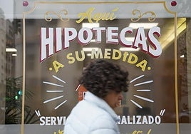 Una mujer pasa por delante de un llamativo cartel de una entidad bancaria.