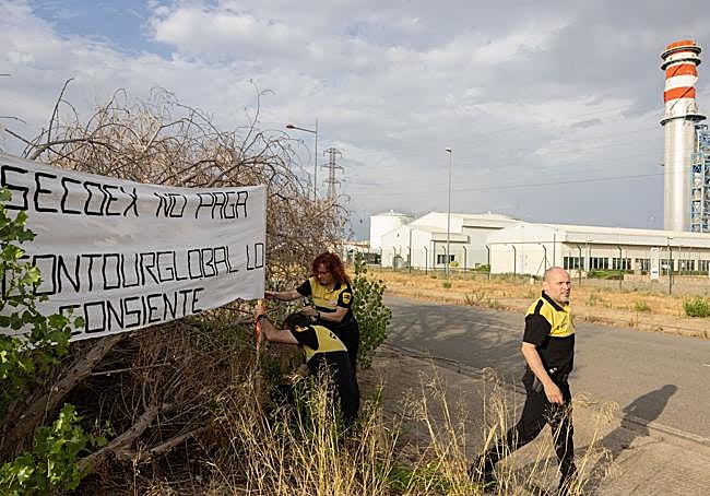 Los vigilantes colocan una pancarta de protesta frente a Contourglobal.