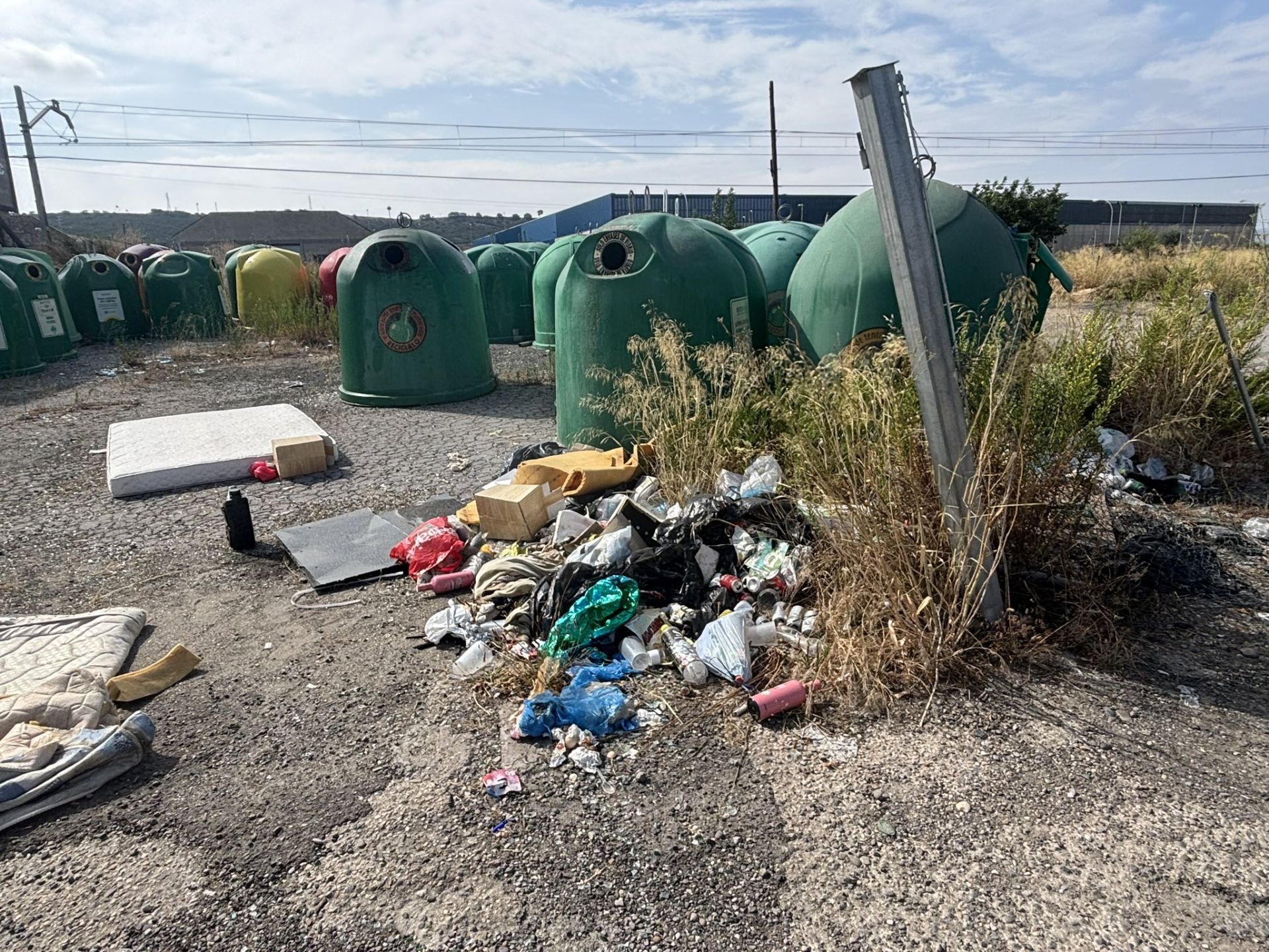 Basurero junto a un depósito de contenedores de vidrio en la avenida de Aragón.