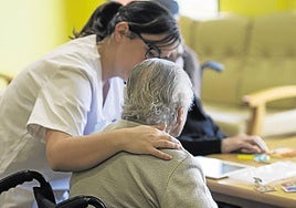 Una trabajadora atiende a una usuaria de una residencia.