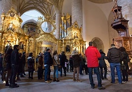 Un grupo de turistas atiende a un guía en el interior de la iglesia del Monasterio de Yuso, en San Millán de la Cogolla.