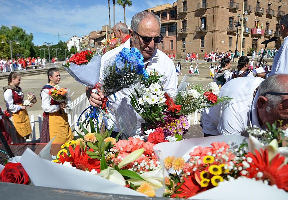 Un miembro de la cofradía de los Santos Mártires, coloca ramos de flores para los patronos de Calahorra en el atrio de la catedral.