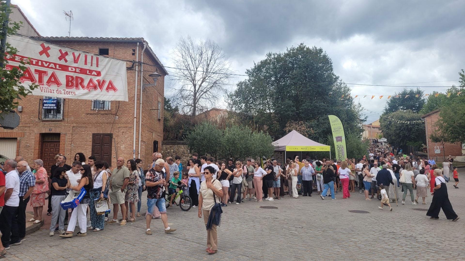 Una larga fila de personas espera turno para su ración de patatas bravas.