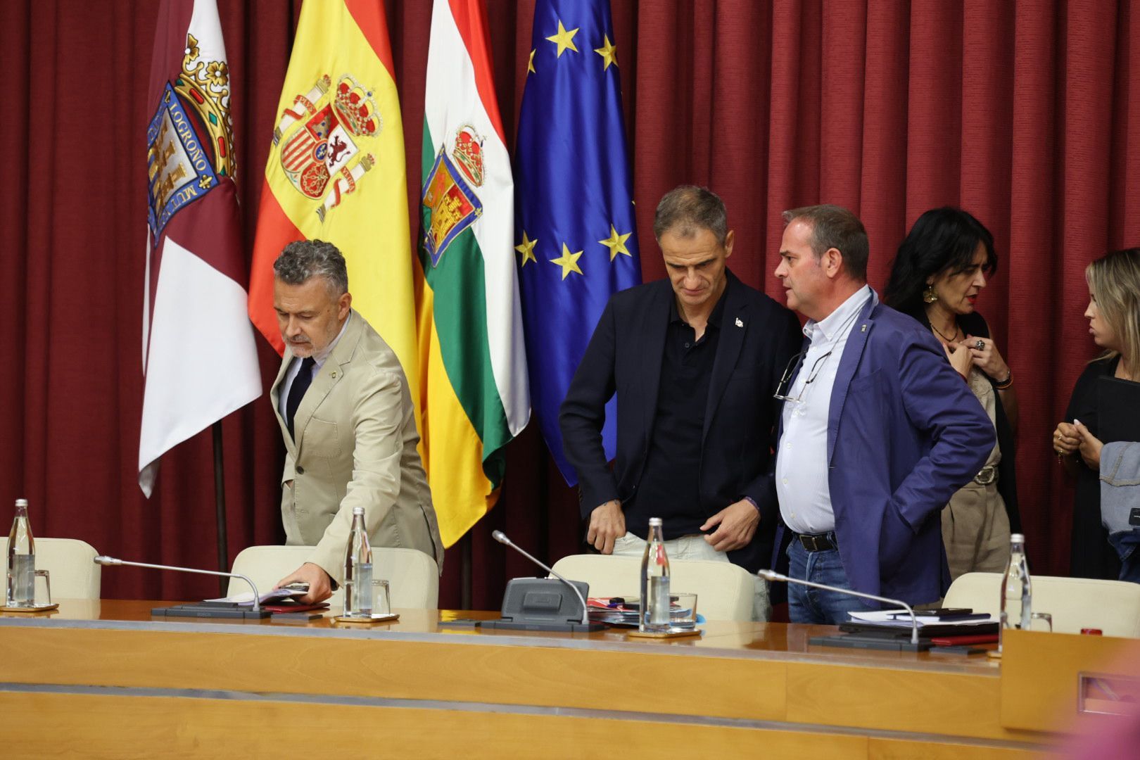 Escobar tomando asiento, con Sáinz e Iglesias a un lado.