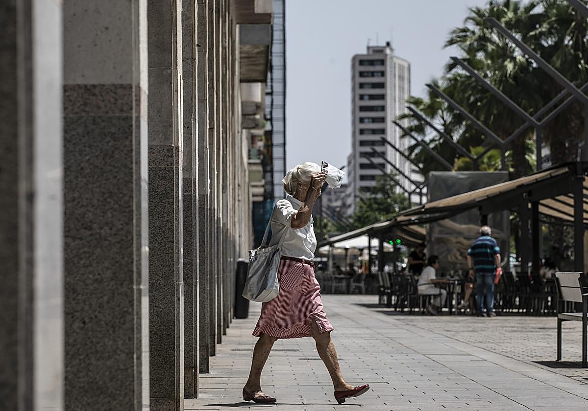 Una mujer se protege del sol en la Gran Vía.