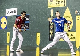 Jaka golpea la pelota mientras Altuna observa la acción.