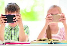 Un grupo de móviles observa el móvil mientras estudia.