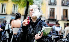 Una joven echa humo tras usar un vapeador.