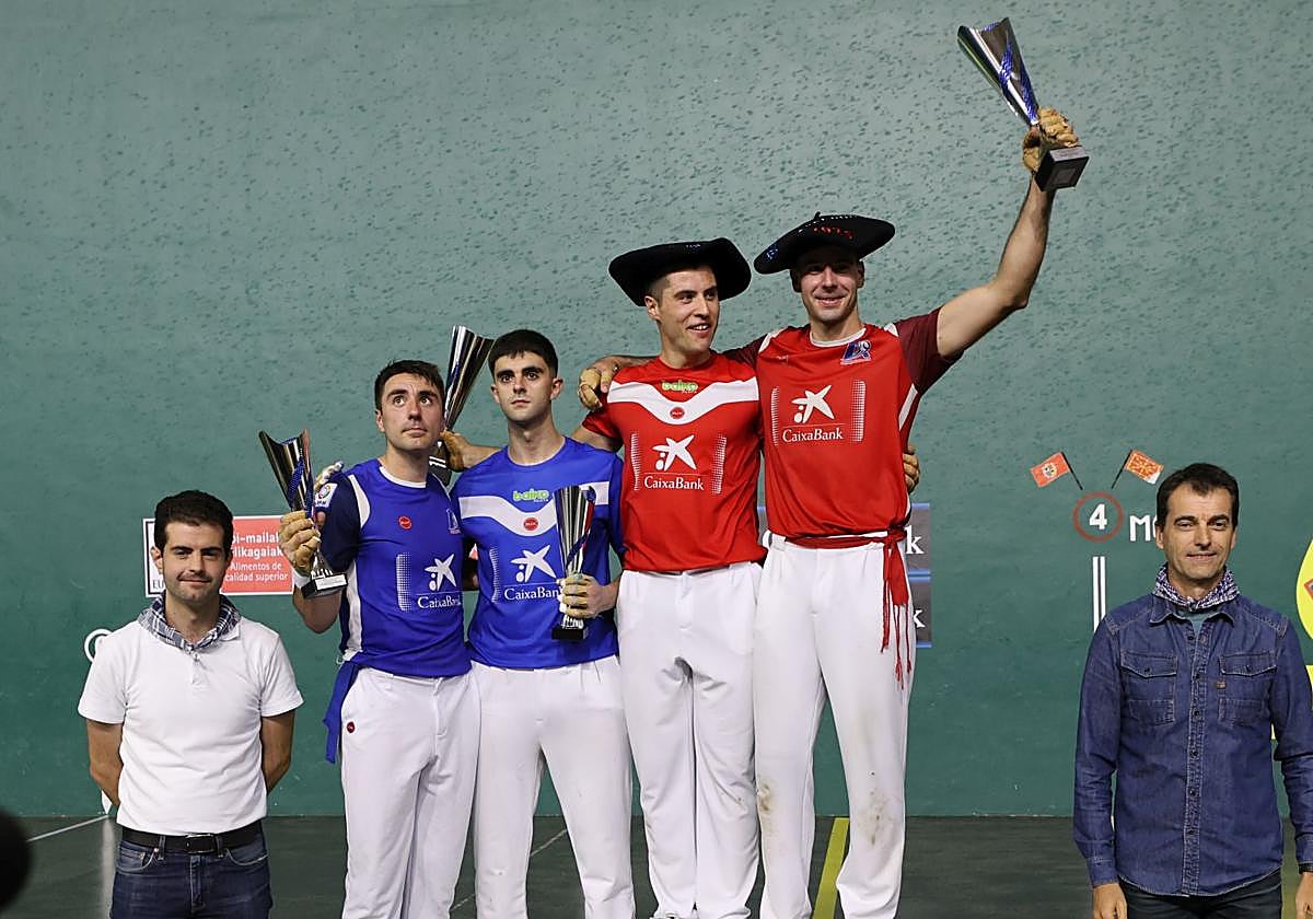 Eskiroz y Darío, de colorado, celebran su triunfo en lo más alto del podio, con el trofeo y la chapela.