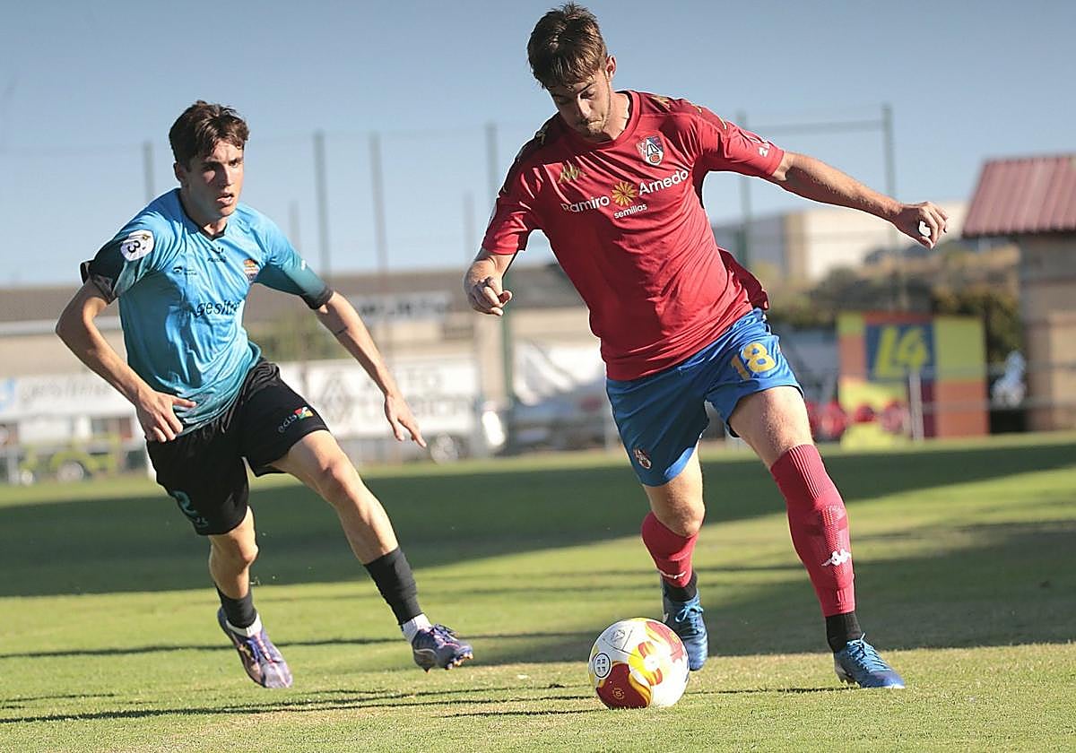 Gorka conduce el balón perseguido por Aitor en el partido de este domingo en el San Roque.