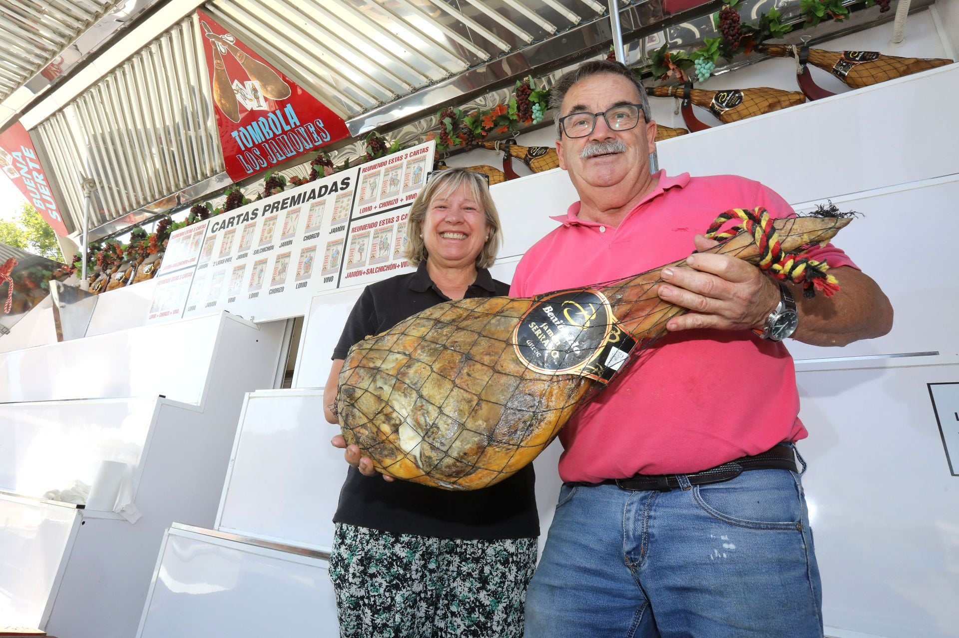 María Ángeles y José Manuel posan en su Tómbola Los Jamones instalada en el recinto ferial de Logroño.