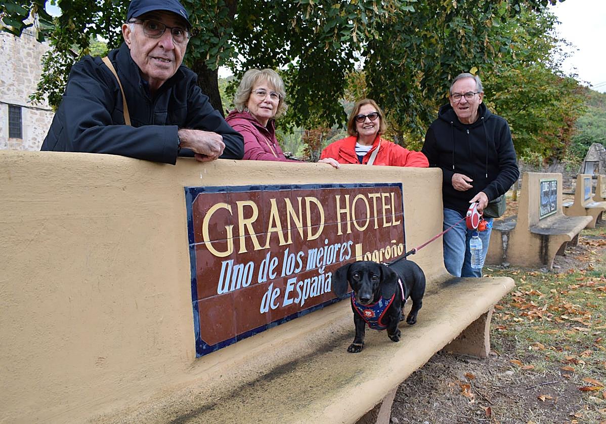 Unos turistas catalanes observan uno de los bancos de Pradillo, al que se sube su perro Matías.