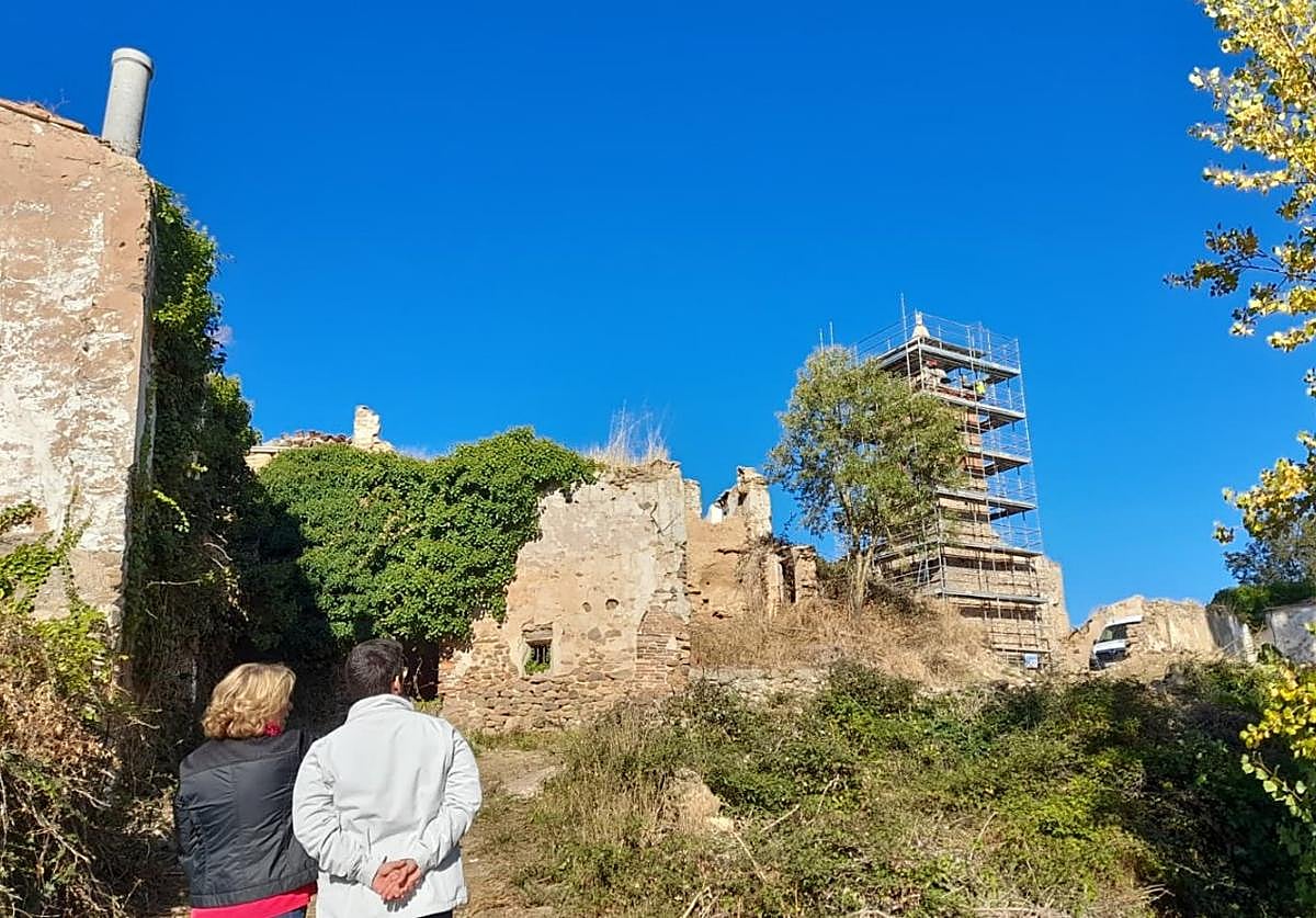 La torre campanario de Oteruelo, rodeada de andamios durante su restauración, predomina entre las ruinas y la vegetación de las calles.