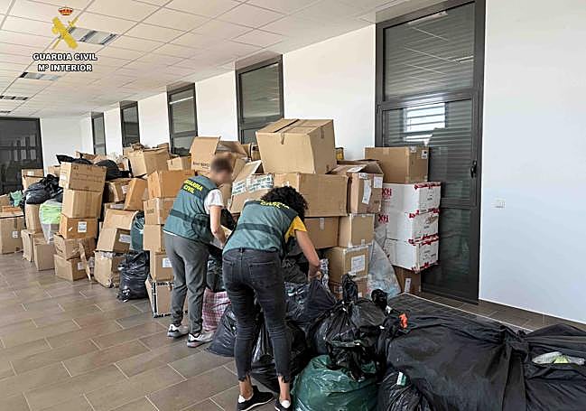 Dos agentes revisan el material robado.