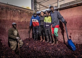 Carmen, con sus trabajadores de temporada, en el lago tradicional de hormigón donde elabora por maceración carbónica.