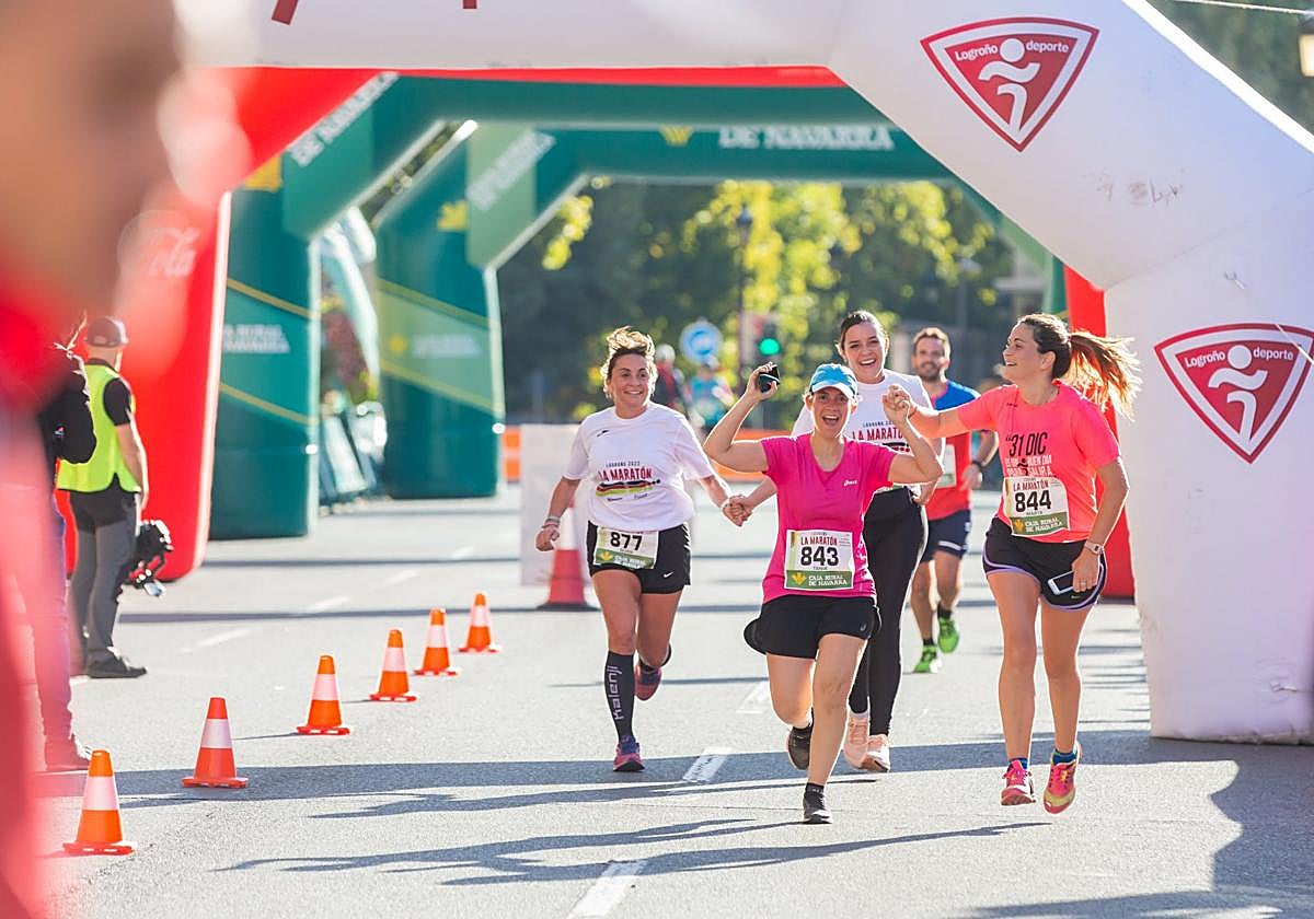 Un grupo de atletas celebra llegar a la línea de meta.