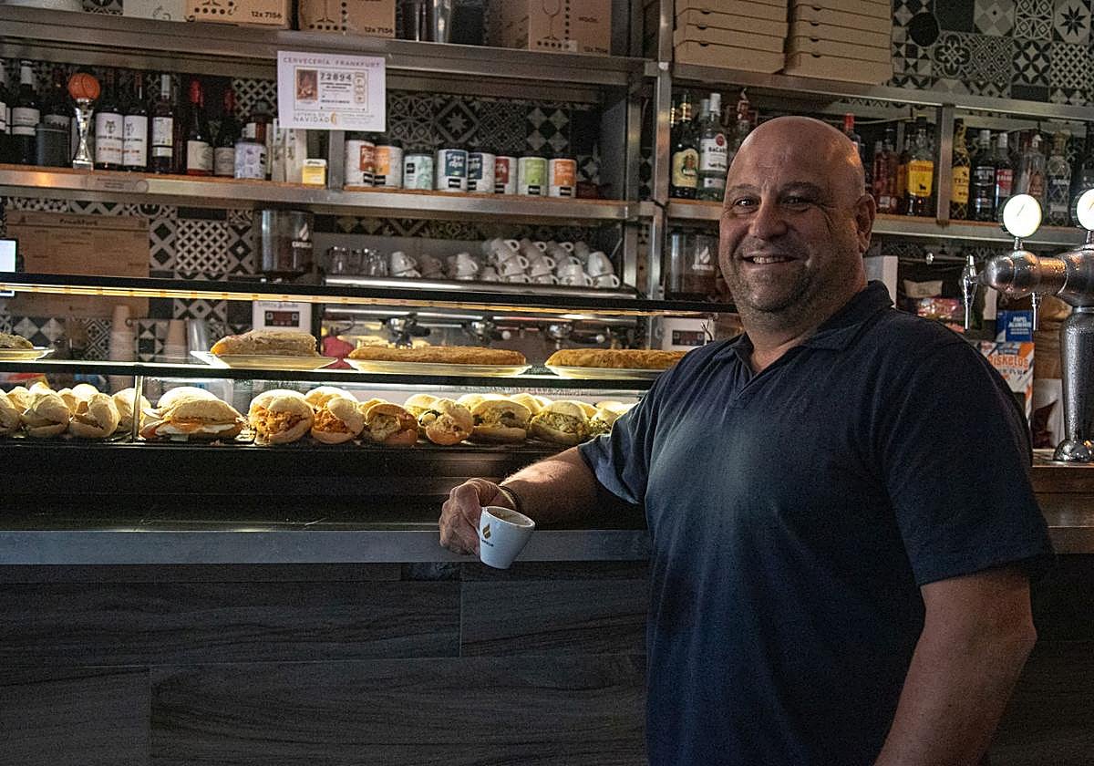 El responsable de la Cervecería Frankfurt posa junto a la nutrida barra de bocatitas del local.