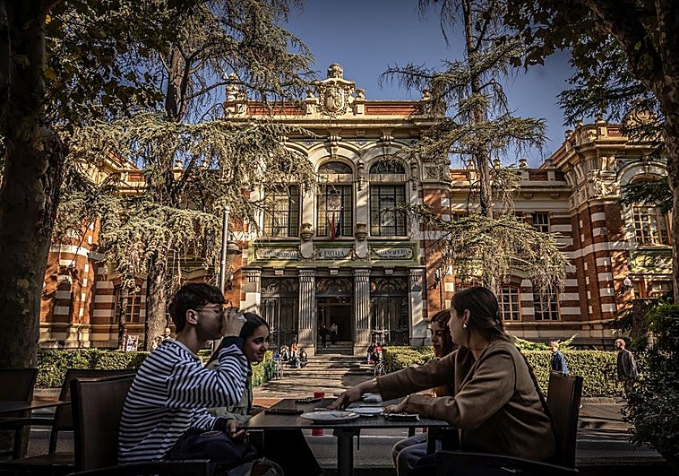 Un grupo de alumnos de la Esdir conversa en la terraza de un café frente al edificio de la escuela.
