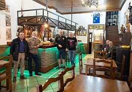 Carmelo Martínez (en el centro, con camiseta negra y pantalón largo), junto a trabajadores y clientes del Vinos Carmelo.