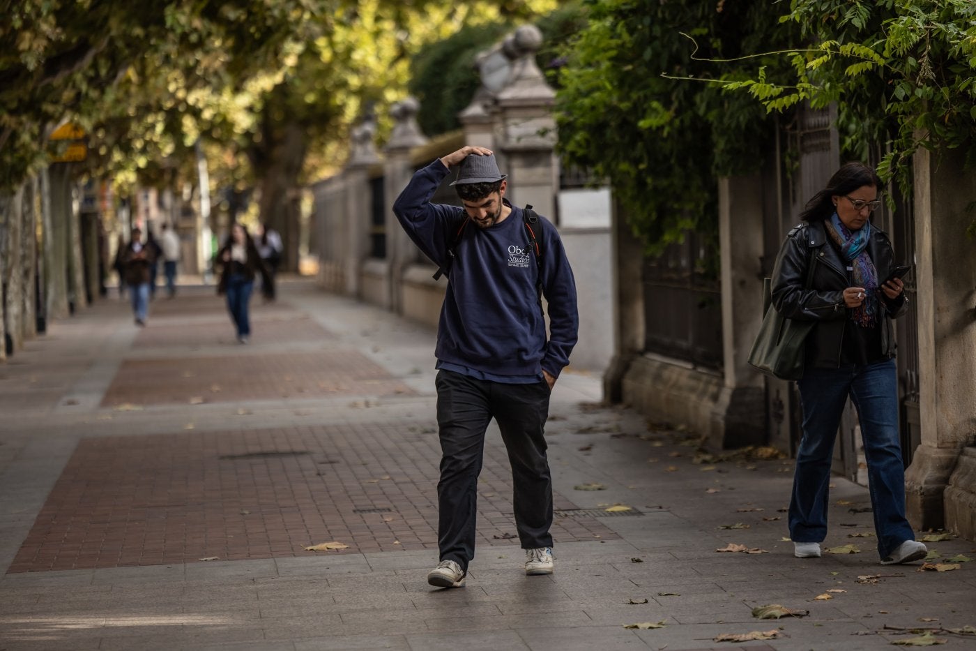 Un joven se sujeta el sombrero frente al viento en el centro de Logroño.