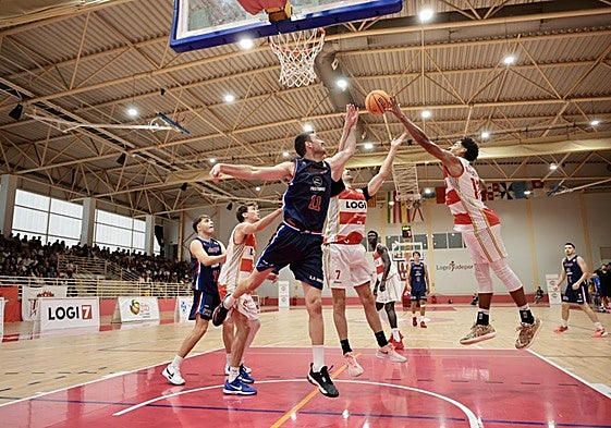 Lucha por un rebote en el partido de Copa España celebrado en Lobete.