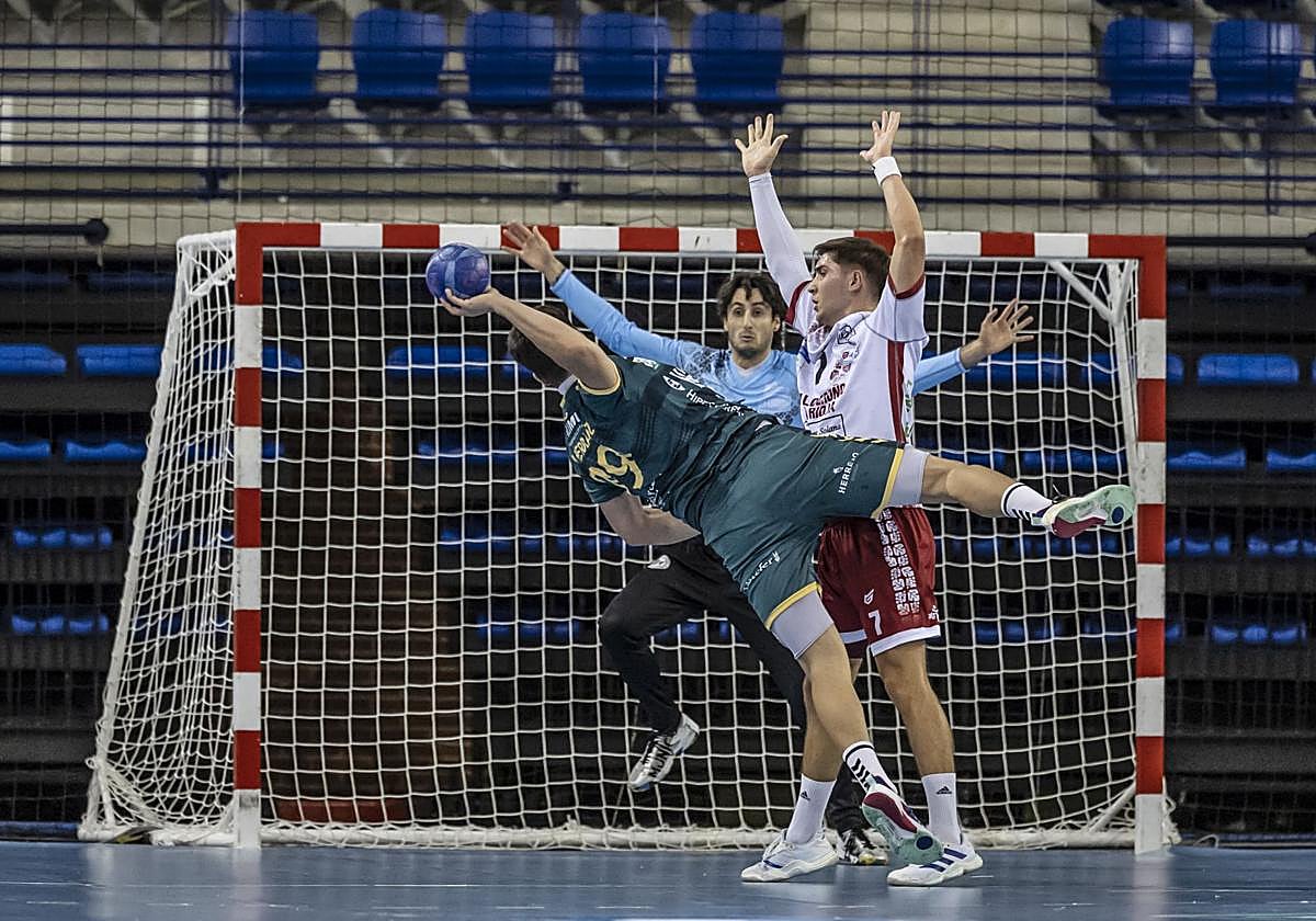 Álvaro Preciado intenta frenar el lanzamiento mientras Xoan Ledo se prepara para detener el balón.