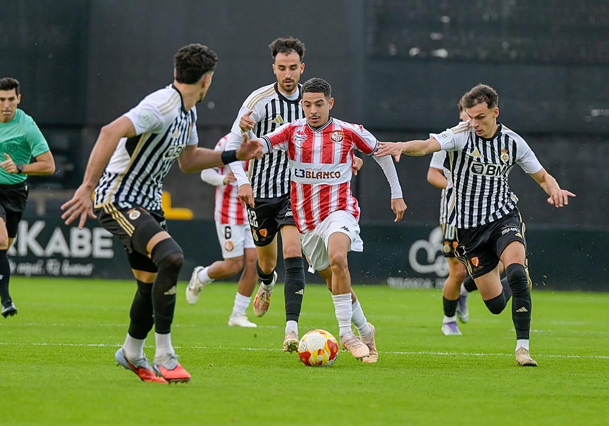 Bilal Kandoussi intenta escaparse de tres rivales, este domingo, en Stadium Gal