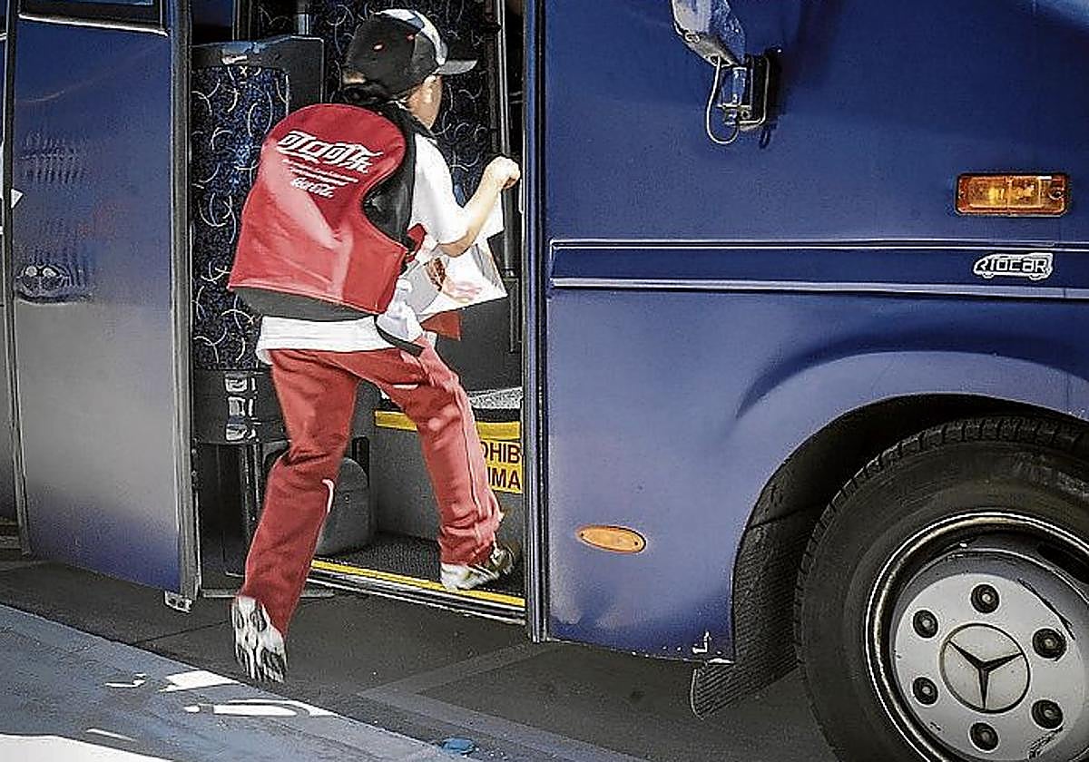 Un alumno sube a un autobús escolar.
