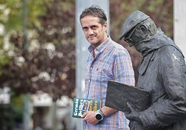 Germán Delibes Caballero posa con su libro junto a la estatua de su abuelo en Valladolid.