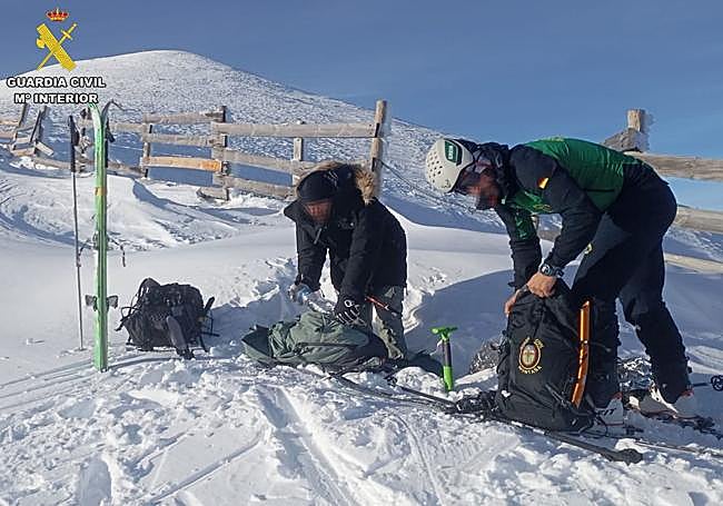 El joven rescatado, un agente del GREIM y, al fondo, el pico San Lorenzo.
