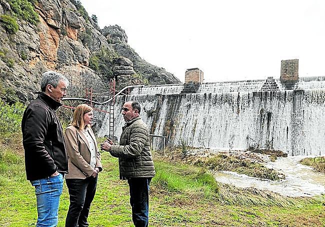 La consejera con Javier Alfaro, de la comunidad de riego, y un técnico en la presa de Añamaza, que seguía desbordada el martes al mediodía.