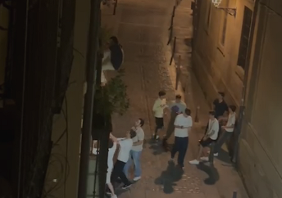 Un grupo de jóvenes ayuda a otro a subir a un balcón del Casco Antiguo.