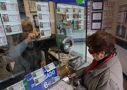 Una mujer compra un boleto de lotería. / Archivo
