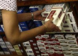 Dependienta de un estanco colocando las cajetillas de tabaco. / Juan Medina (Reuters)