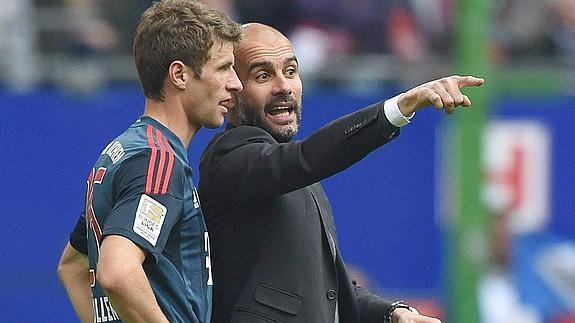 Müller (i) escucha las instrucciones de Guardiola. 