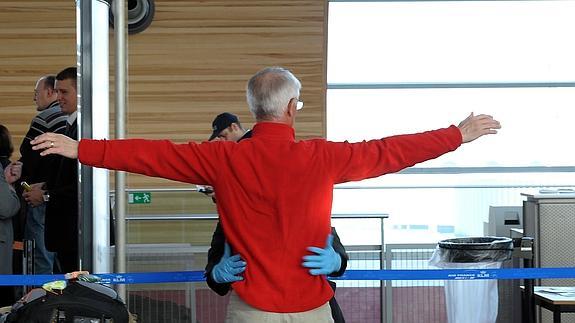 Un agente de seguridad registra a un pasajero en un aeropuerto de EE UU. 