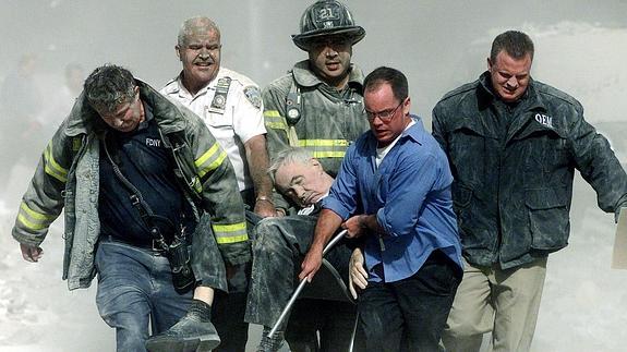 Rescate de uno de los heridos en medio de la polvareda provocada por el derrumbamiento de las Torres Gemelas. Archivo