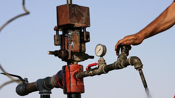 Un trabajador cierra la válvula de un oleoducto en una refinería de petróleo. 